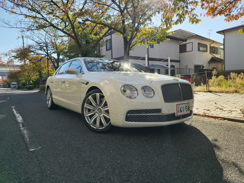 Biały Bentley Flying Spur widoczny z przodu na drodze, luksusowy samochód z Japonii