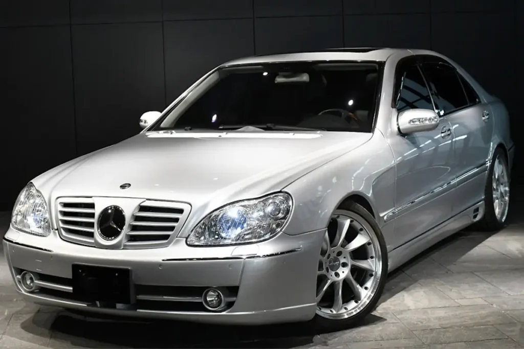 Srebrny Mercedes klasy S widoczny z przodu w hali, samochód z Japonii dostępny do importu